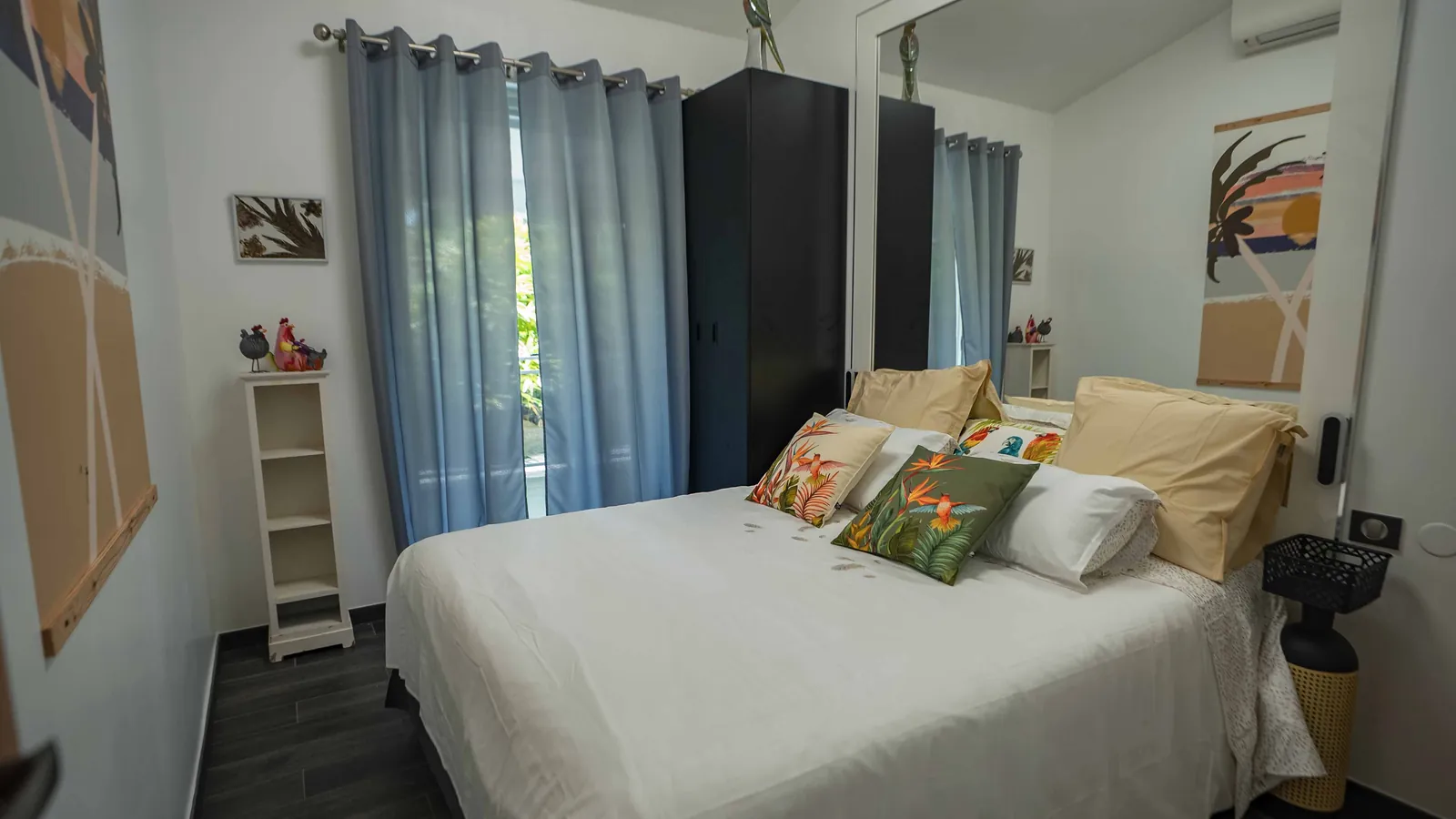 Chambre Birds and Koï — rideaux gris-bleu, armoire noire et coussins d'oiseaux, villa House of Harmony, Goyave