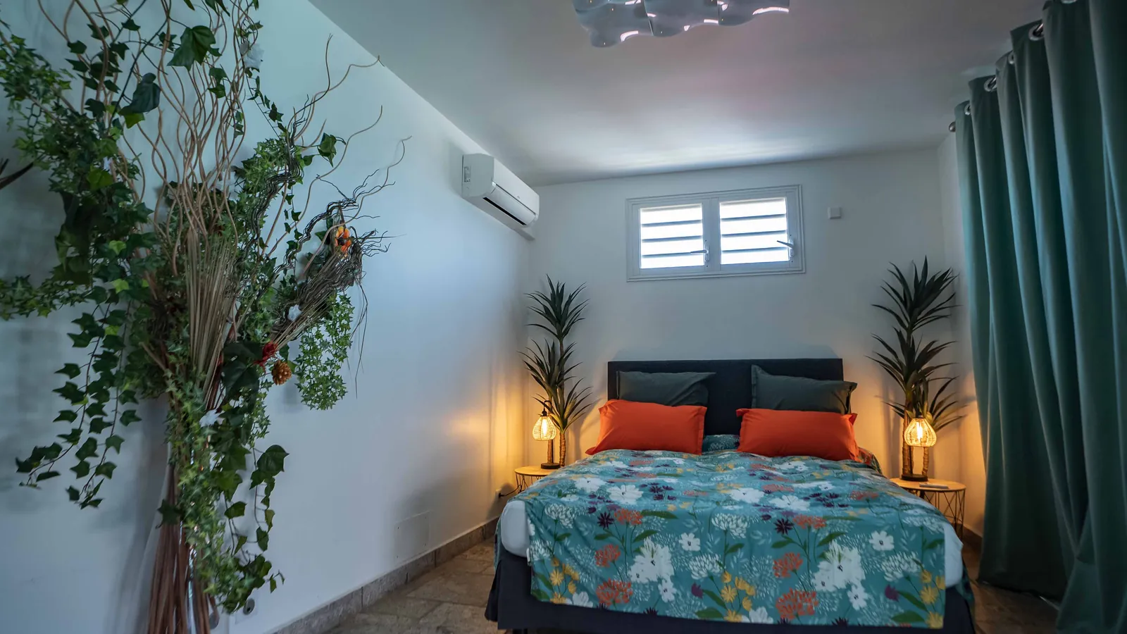 Chambre Cocktail — mur végétal, lampes de rotin et coussins orange brûlé, villa House of Harmony, Goyave