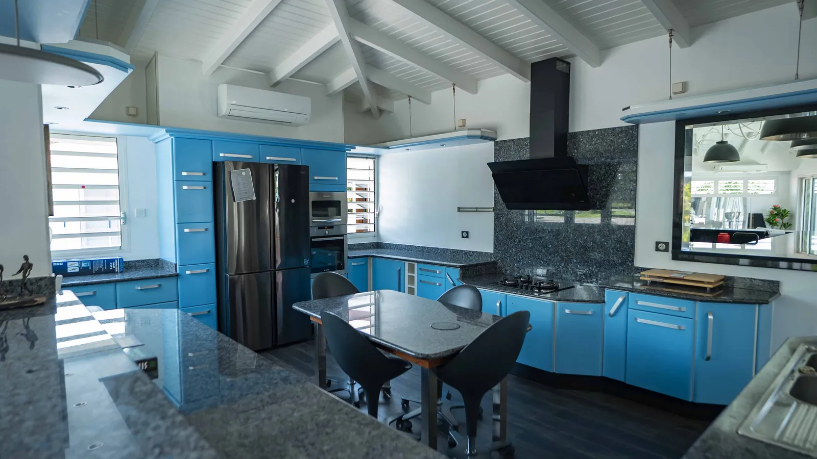 La cuisine bleue — laque bleue, granit perlé et réfrigérateur noir