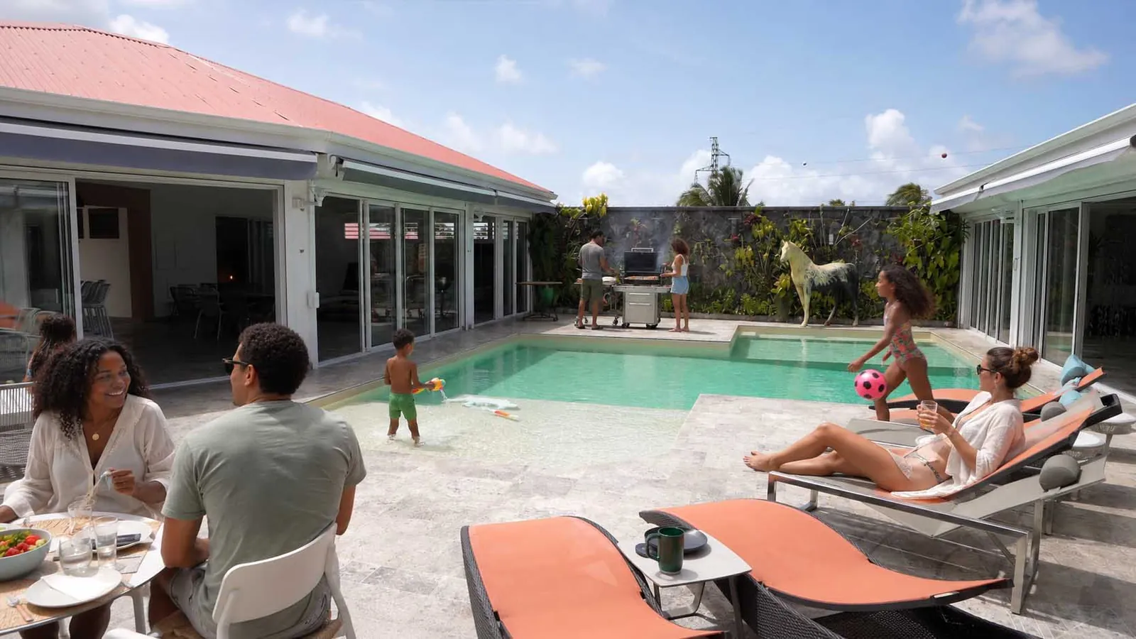 Une famille au bord de la piscine, barbecue en cours